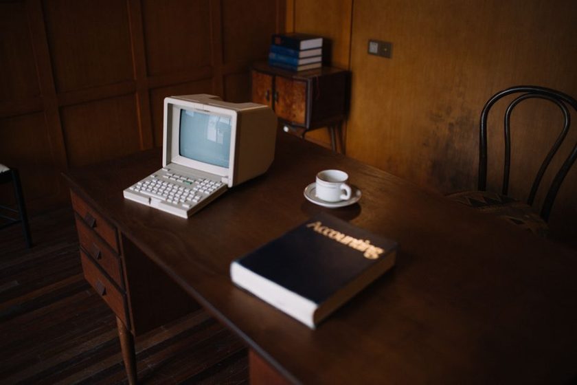An open household ledger book with ruled columns, a fountain pen resting across the page
