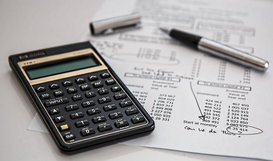 Two people sitting at a table sharing one open ledger book